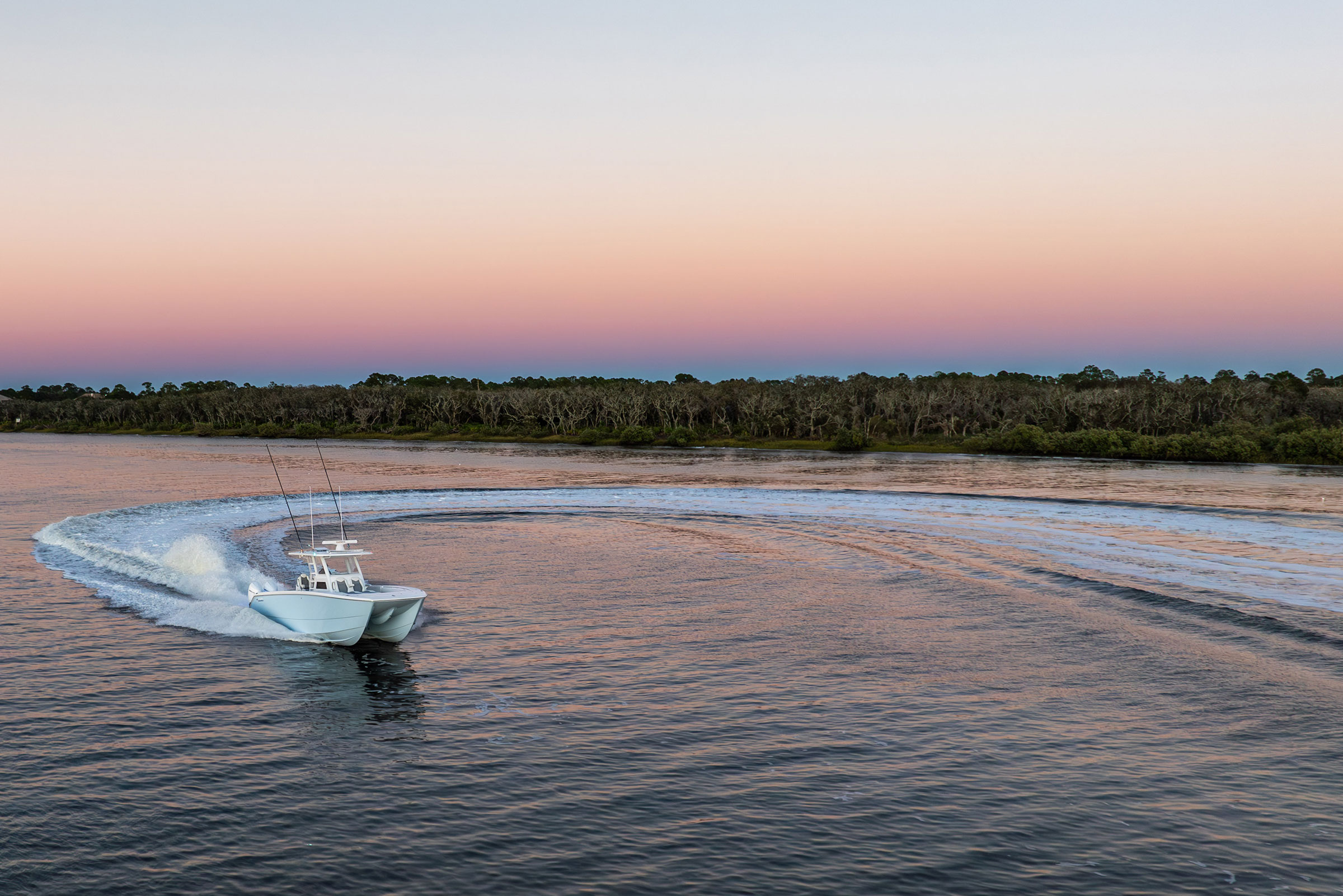 Invincible 38' Catamaran making surf lines in the water