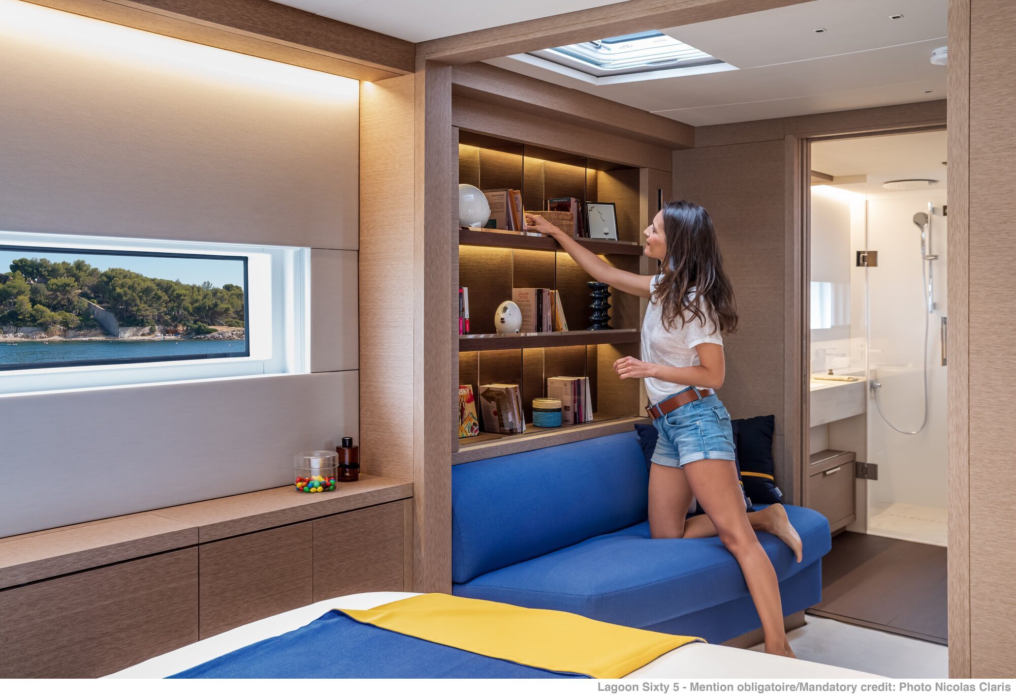 Lagoon Sixty 5 catamaran cabin interior showing seating area and built-in shelving Lagoon Sixty 5 catamaran cabin interior showing seating area and built-in shelving
